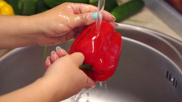 Woman Washing Red Pepper in Kitchen. Homemade Food Concept. Slow Motion