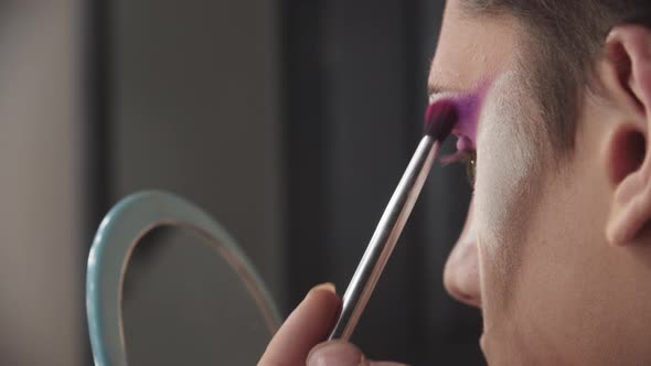 Drag Artist  Young Man Applying Purple Eyeshadows Under His Brow