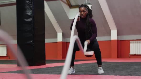 Sports Training  Africanamerican Woman Doing Exercises with Her Hands Using Ropes