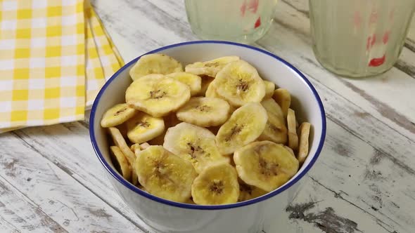 Bowl with dried sweet banana chips close up 