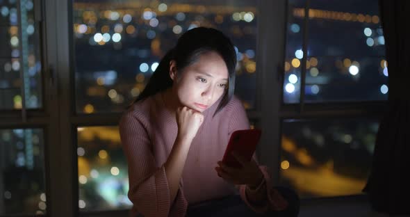 Young woman check on mobile phone at night