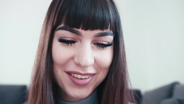 close up of caucasian young attractive woman with face make up and modern hairstyle smiling in slow