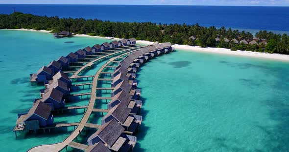 Daytime fly over travel shot of a white paradise beach and blue ocean background in colorful 4K