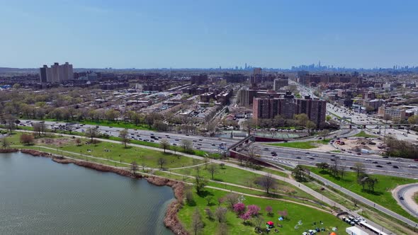 An aerial view high over Meadow Lake on a beautiful day in Queens, NY. There is a flock of birds fly