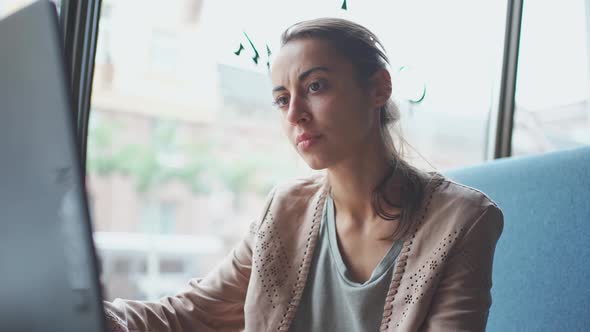 Businesswoman Dressed Casual Sitting in Cafe and Using Laptop