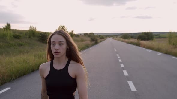 Young Girl Walking on Road and Breathing During Morning Workout at Nature