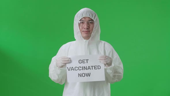 Asian Man Wear Uniform Ppe And Holding Get Vaccinated Now Sign In The Green Screen Studio