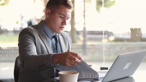 Business Man in Suit Using a Laptop in Cafe