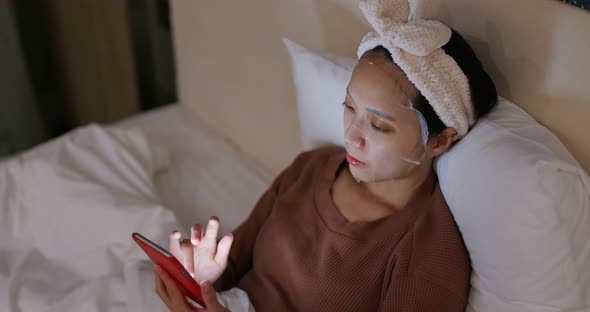 Woman use of mobile phone with apply paper mask on face