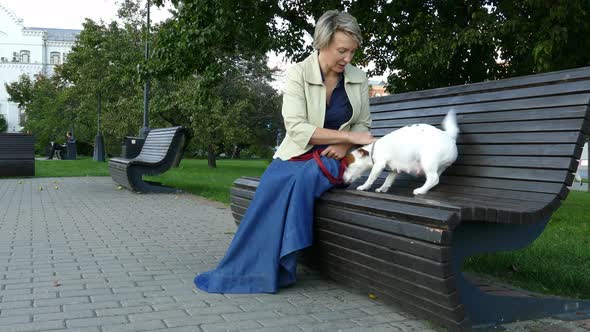 Woman Sitting in Park with Pregnant Dog