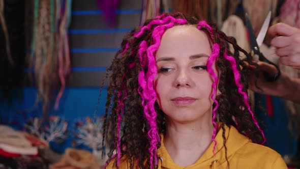 Unrecognizable Person Makes Curly Hairstyle for Young Woman in Salon