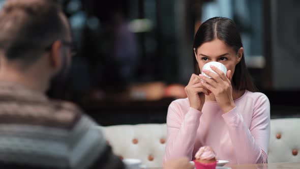 Happy Woman Drinking Coffee Tea with Man at Romantic Meeting in Cafe