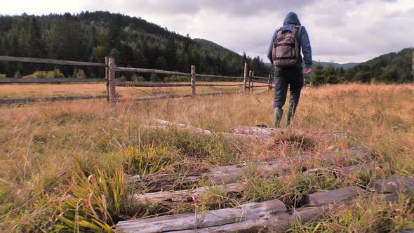 Man in work boots going through field of grass. Mans legs stepping on grass. Carpathians