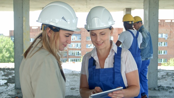 Construction worker and engineer working on building site