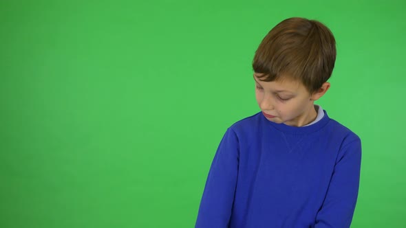 A Young Cute Boy Adjusts His Clothes and Smiles at the Camera - Green Screen Studio