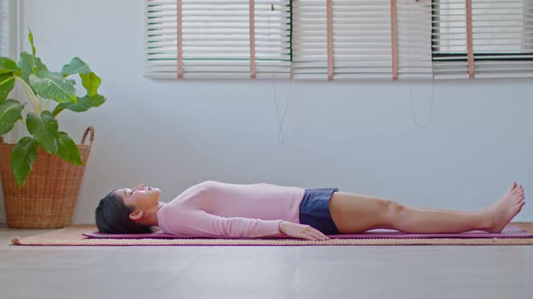 Calm of Asian woman practice yoga Dead Body or Savasana pose with meditation