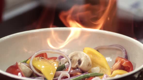 Flambe of Paprika, Mushrooms and Purple Onions in a Ceramic Frying Pan. Close-up of Juicy Vegetables