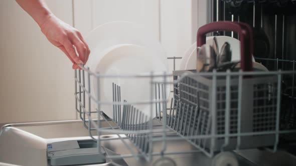 Housewife Taking Out Clean Plates From Dishwasher Machine