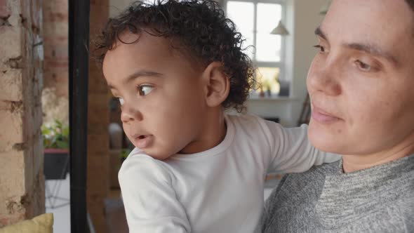 Close Up of Mother and Toddler Looking out Window