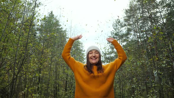 Positive Woman in Hat Raises Hands Spending Time in Forest