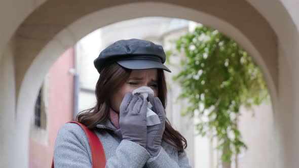 A Young Girl With A Runny Nose Uses A Napkin, Sneezes Into A Napkin Sick Girl Feels Bad