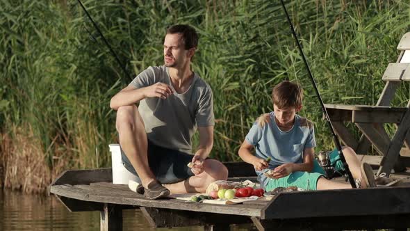 Family Enjoying Meal By the Lake While Fishing