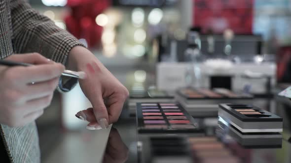 Makeup, Shopper Girl with Brush in Hands Is Testing Cosmetics for Eye Makeup in Store