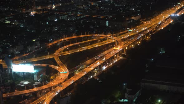 movement of cars in the highway and the bridge in the nighttime big city. view from above