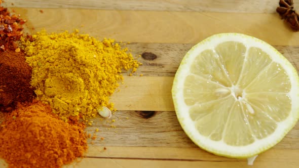 Various spices with lemon slice and knife on chopping board 4k