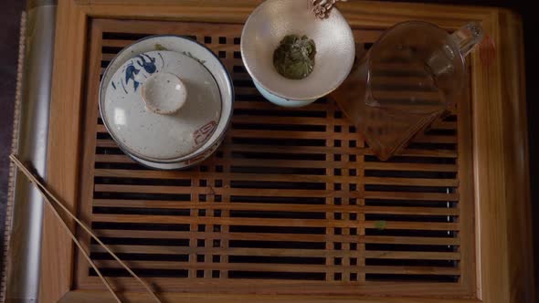 Close Up Hands of Tea Lover Taking Green Tea Cup From Wooden Table Top View