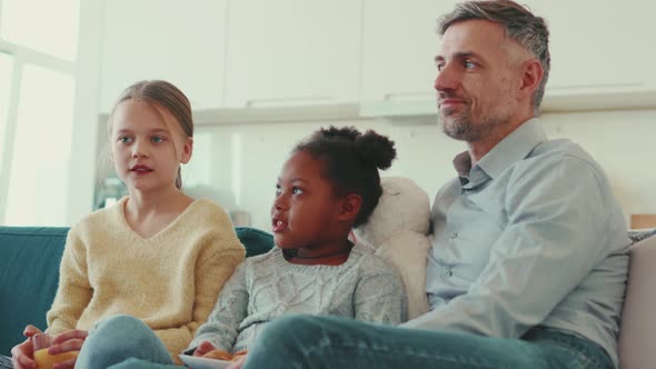 Happy mature father talking with his multinational daughters