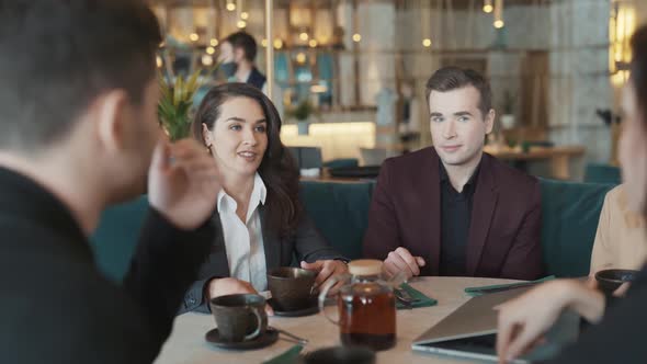 Diverse Group of Business Coworkers Sitting at a Table in Restaurant