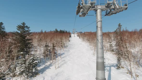 Riding on Ski Lift Above the Slopes in the Morning