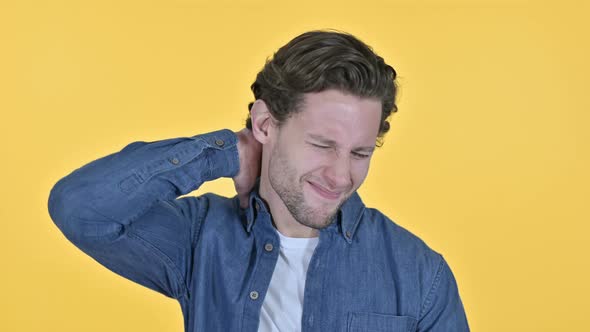 Exhausted Young Man with Neck Pain on Yellow Background