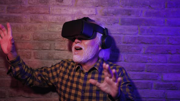 Asian senior man having fun playing with innovated virtual reality glasses - Metaverse concept