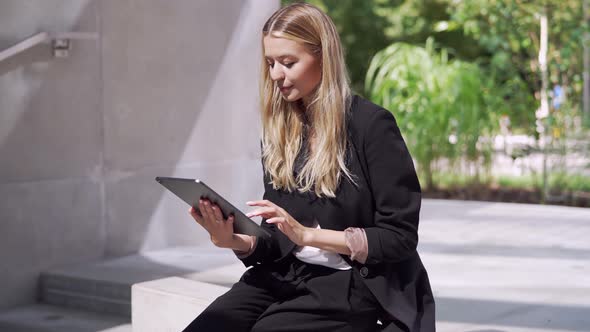 Businesswoman Using Tablet on Street