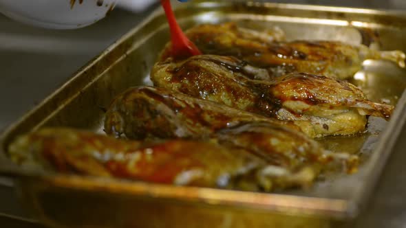 Chef Hands Smear Turkey Chicken Legs with Red Sauce. Lrrl Baking in Buffet Cafeteria Steel Container