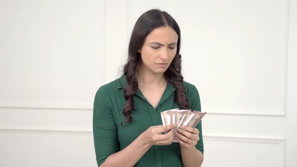 Sad Indian woman counting money