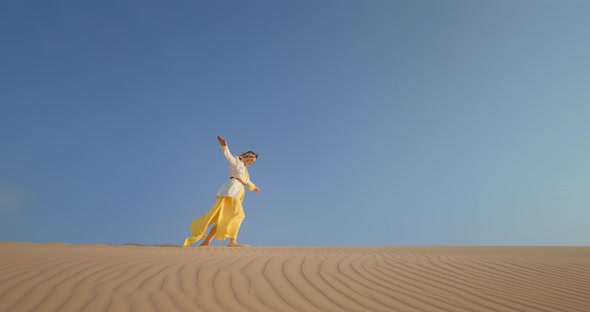 Cheerful Woman Walking on Top of Sand Dune