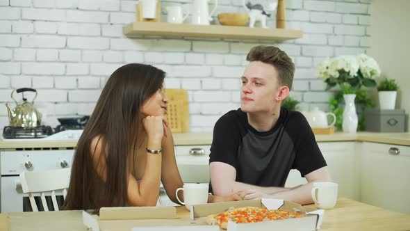 Smiling Teenage Couple Having Lunch in Kitchen