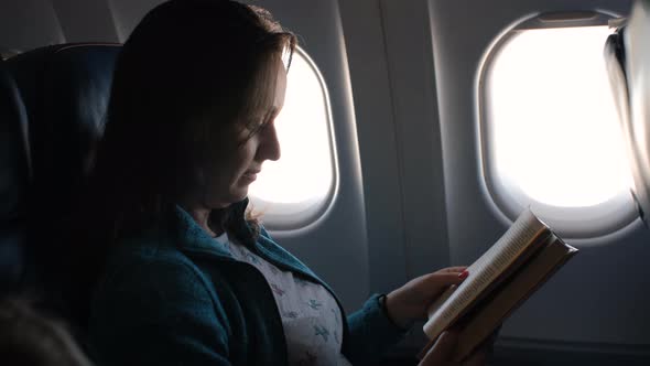 Female Passenger of Airplane Reading Book