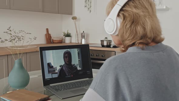 Senior Woman Speaking with Female Colleague on Video Call from Home