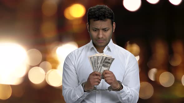 Handcuffed Businessman Holding Dollar Banknotes.