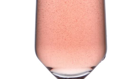 Closeup of Glass with Sparkling Rose Wine Decorated Gold Star Confetti Celebration Party