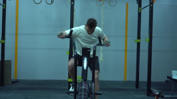 Athletic Middle Aged Man Training on Air Resistance Bike.