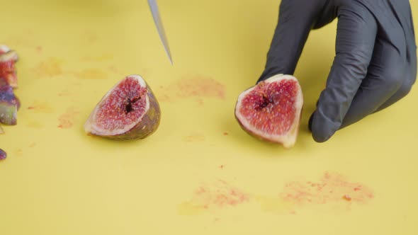 Person Cuts Juicy Fig Along Half and Halves Into Slices