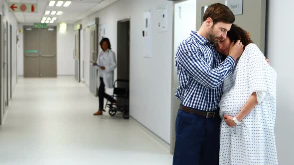 Man embracing pregnant woman in corridor