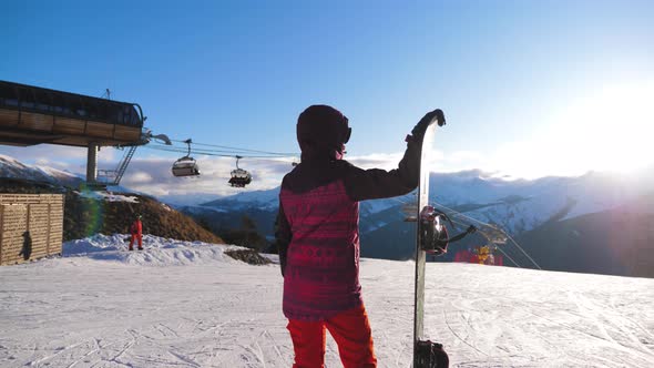 Girl Snowboarder with Snowboard on Mountain Top on Ski Resort, Winter Sports and Winter Vacation