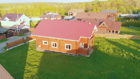 Wooden Cottage Houses with Red Roofs and Fresh Green Lawns