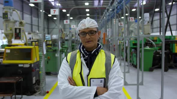 Warehouse female worker looking at camera with arms crossed